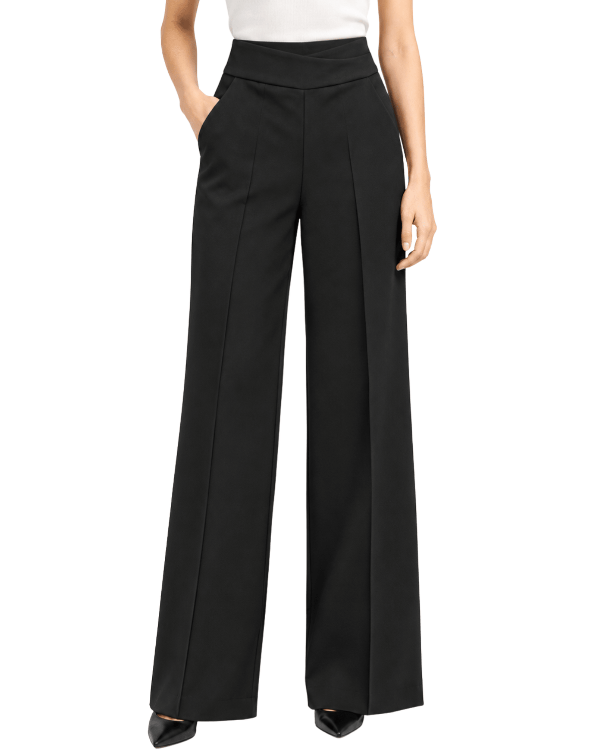 A model wearing black wide-leg trousers with a high waist and front crease, paired with a white top and black pointed shoes, shown against a plain white background.