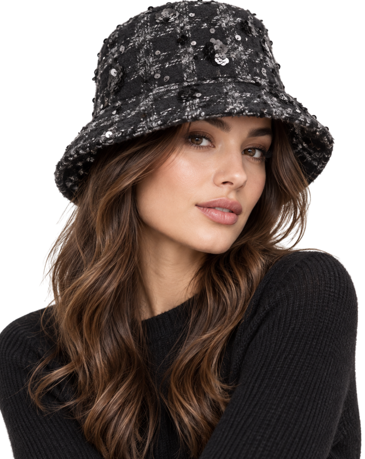 A woman wearing a black bucket hat embellished with silver sequins and a small silver heart charm, paired with a black ribbed sweater against a plain white background.