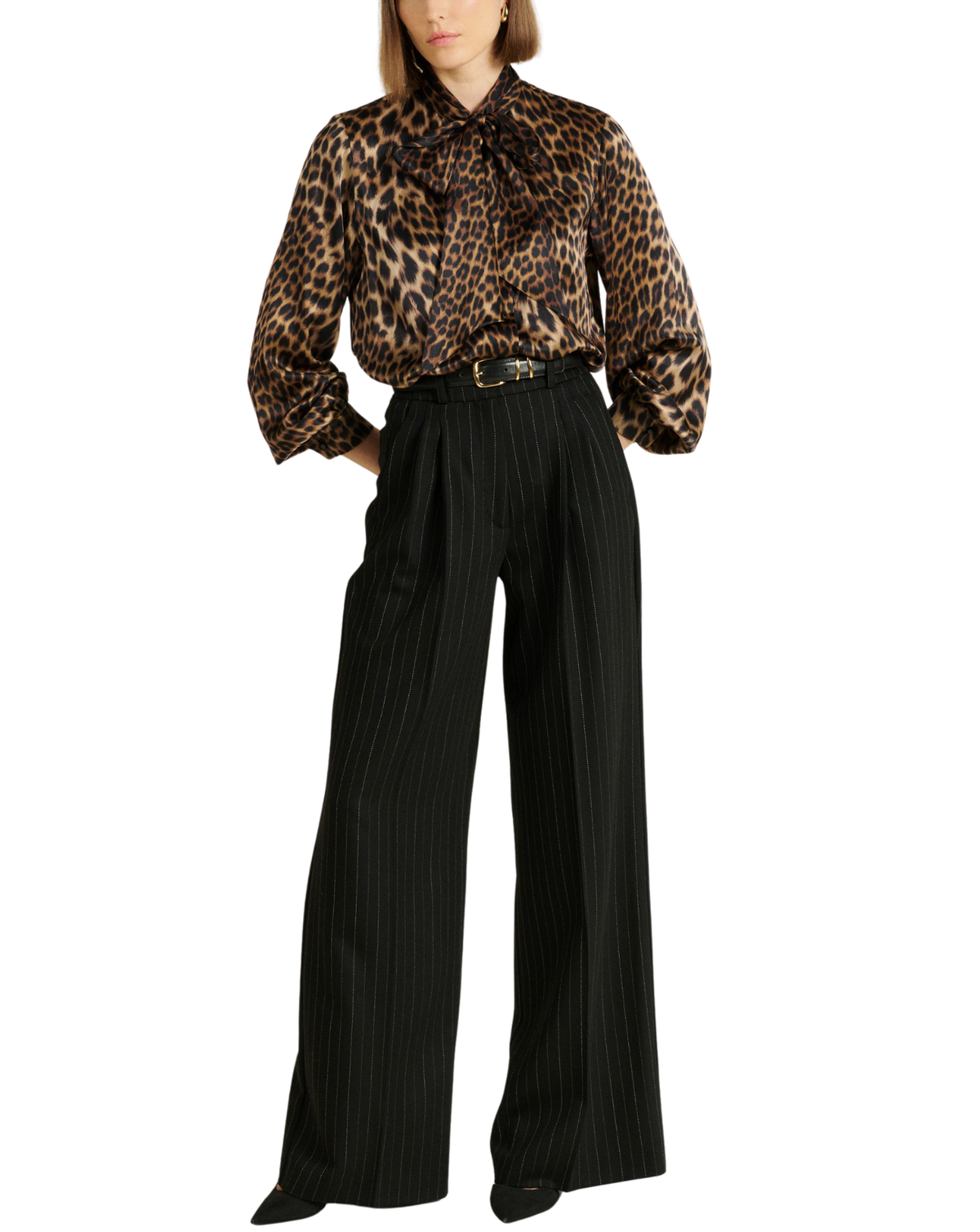 A model wearing a leopard-print long-sleeve blouse with a tie-neck detail and black pleated wide-leg trousers, shown against a plain white background.