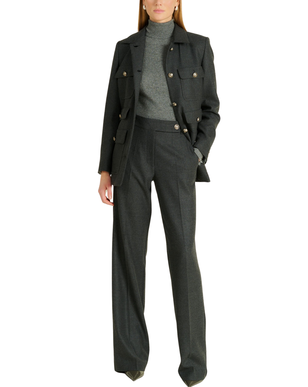 A model wearing a dark charcoal gray double-breasted blazer with gold buttons, matching wide-leg trousers, a gray ribbed turtleneck, and brown pointed-toe heels, shown against a plain white background.