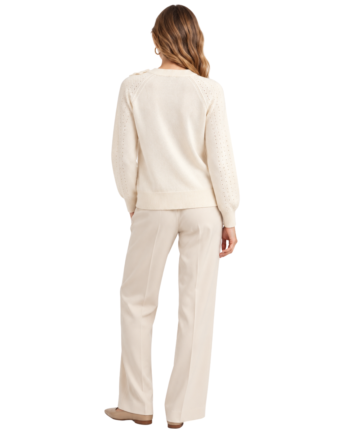 A woman shown from the back wearing a cream knit sweater with textured lace-up shoulder details and matching cream wide-leg trousers, photographed against a solid white background.