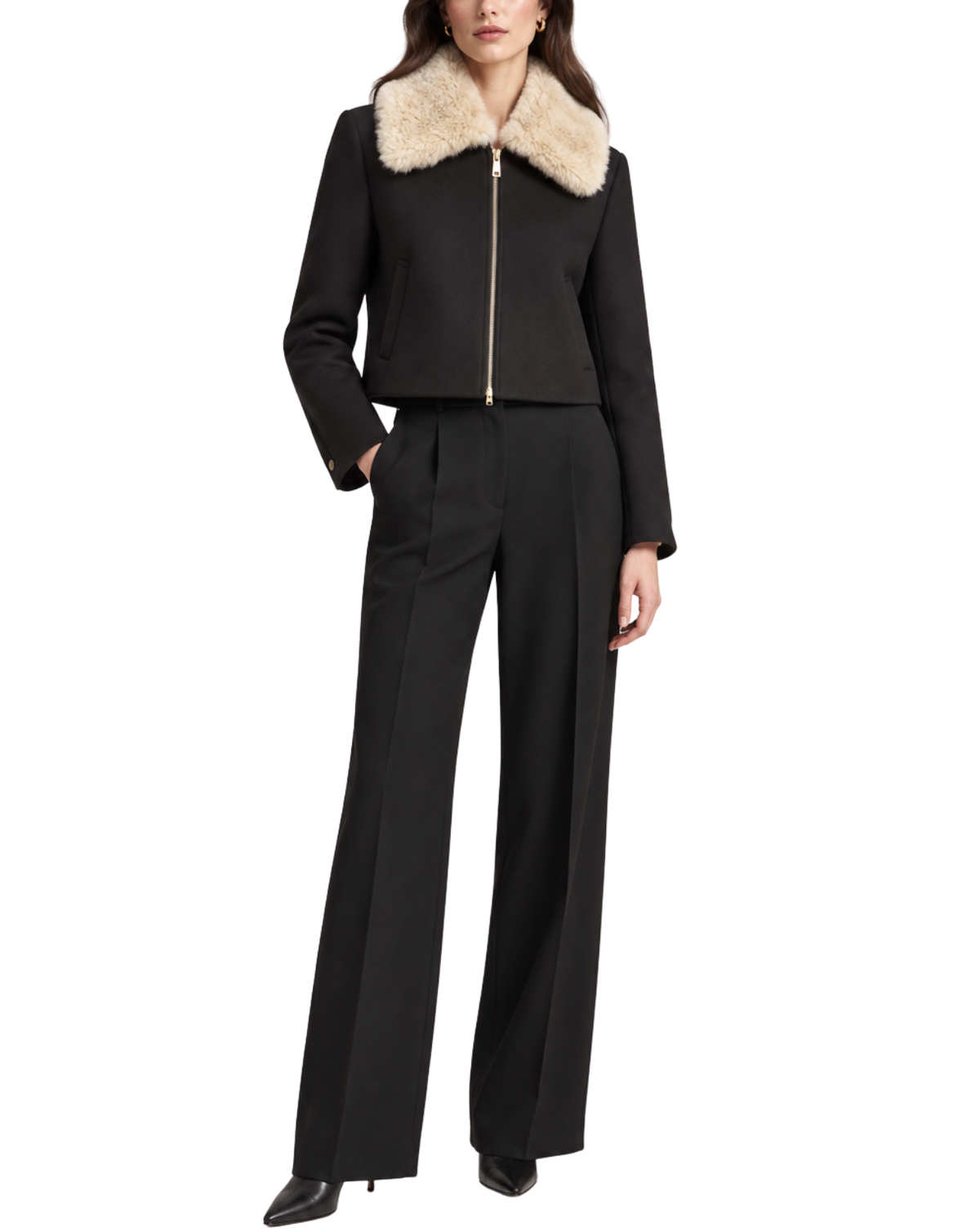 A model wearing a black cropped jacket with a beige faux-fur collar and a gold front zipper, paired with matching black wide-leg trousers, on a solid white background.