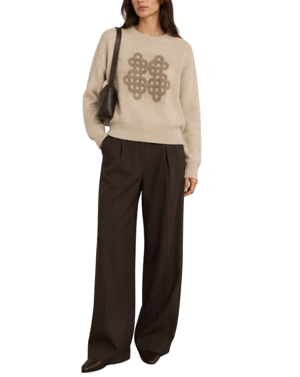 A model wearing a beige knit sweater with a brown geometric pattern on the chest, paired with dark brown wide-leg trousers and a dark brown shoulder bag, set against a plain white background.