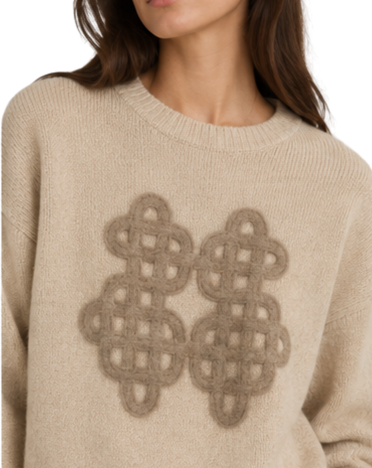 A close-up of a woman wearing a beige knit sweater with a large taupe geometric pattern on the front.