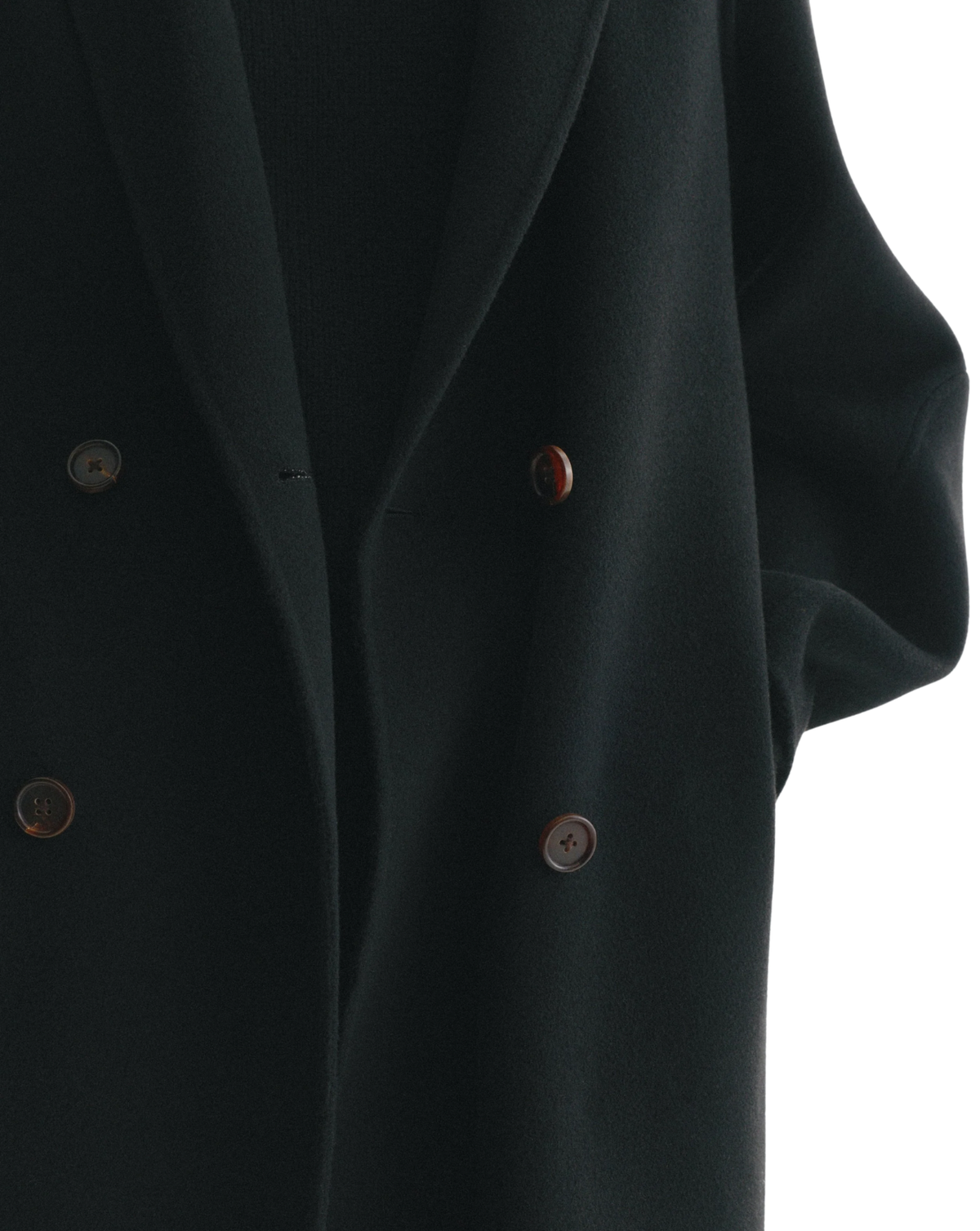 Close-up of a dark green double-breasted blazer with brown buttons, showing the lapel and fabric texture against a white background.