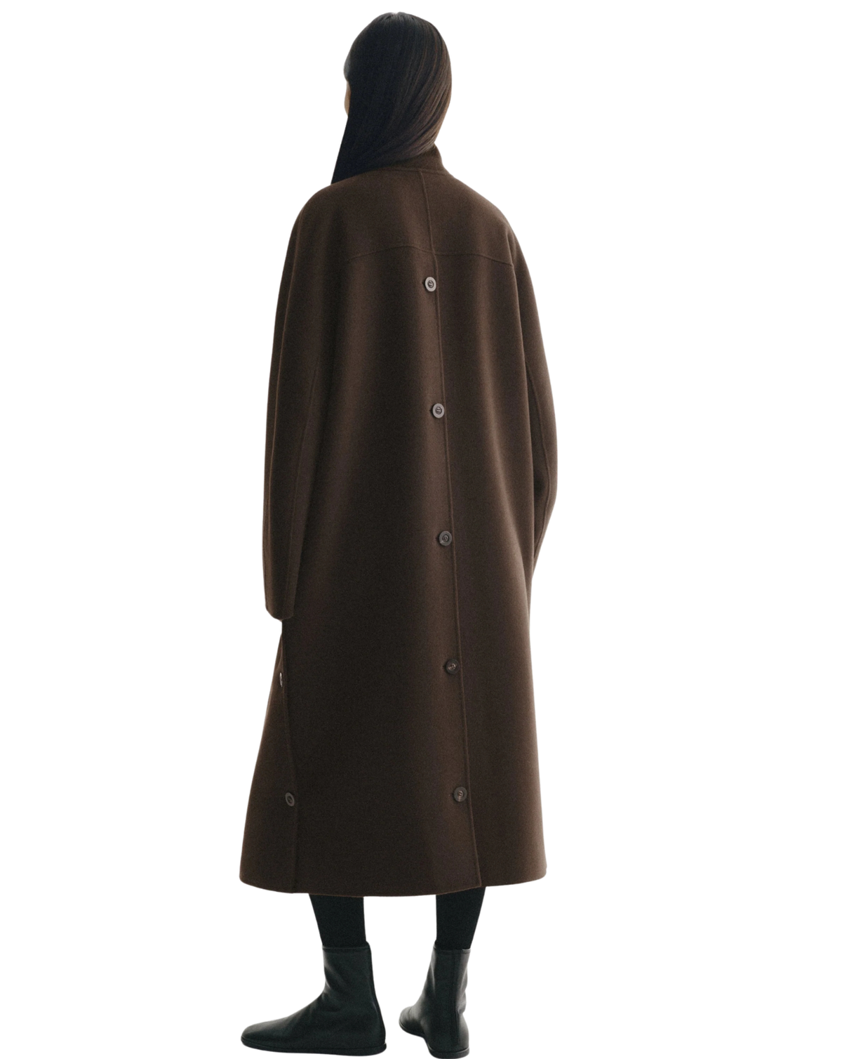 A person shown from the back wearing a long brown coat with a high collar and a row of dark buttons down the center back, paired with black boots against a plain white background.