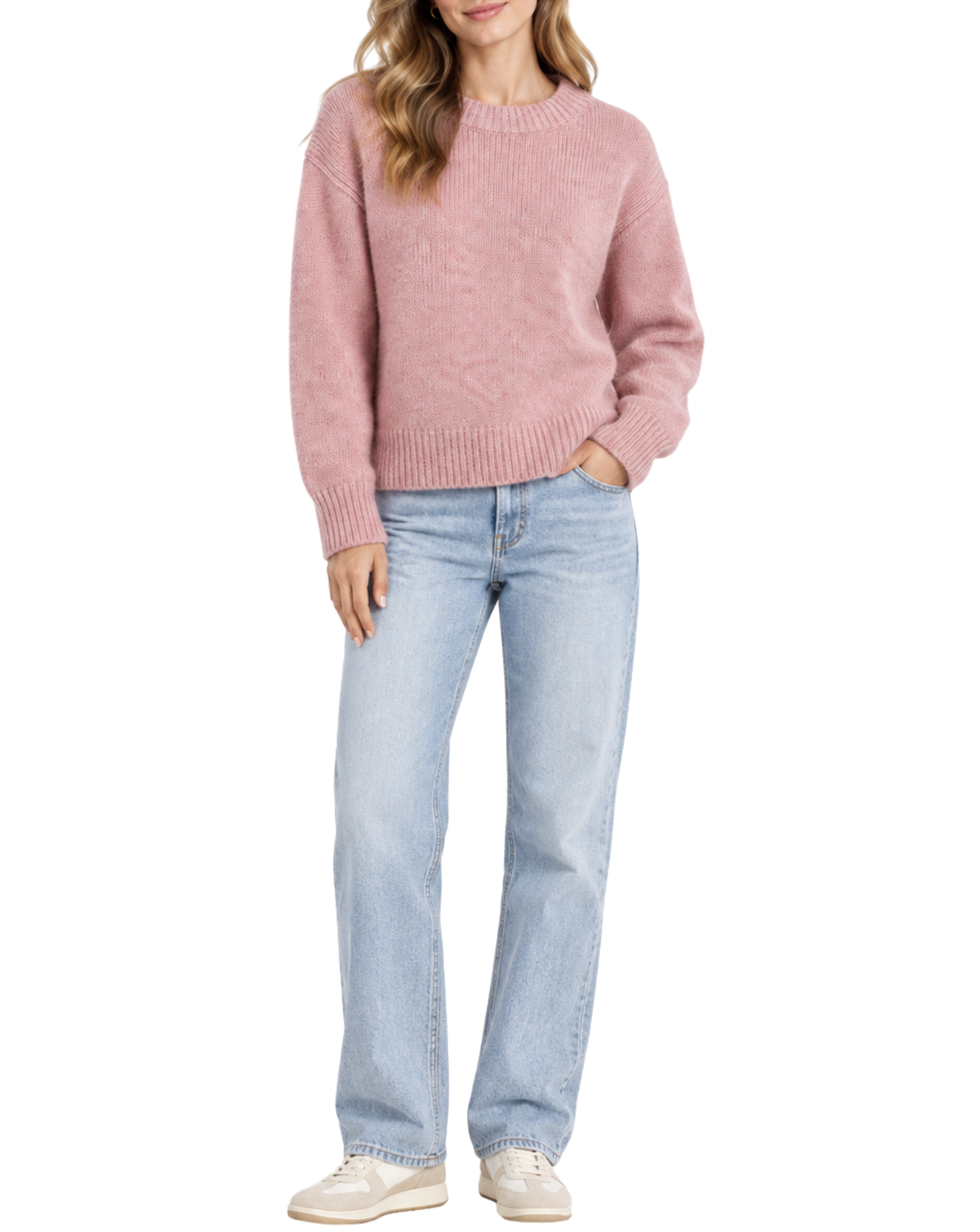 A woman wearing a dusty pink knit crewneck sweater, light-wash blue jeans, and white sneakers, shown from the waist down against a plain white background.