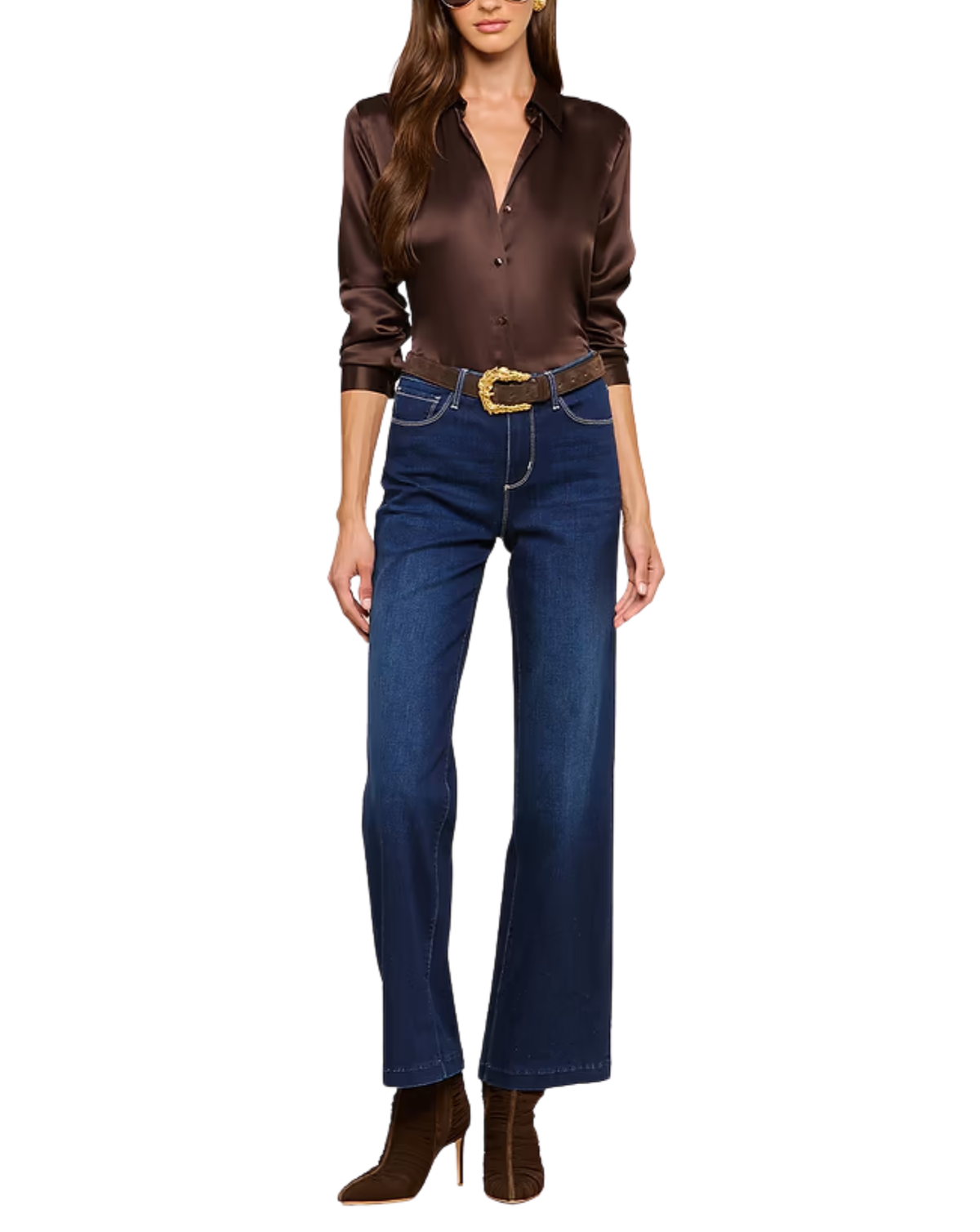 A woman modeling a dark brown satin button-up shirt, dark blue straight-leg jeans with a gold-buckled belt, and brown suede ankle boots against a plain white background.