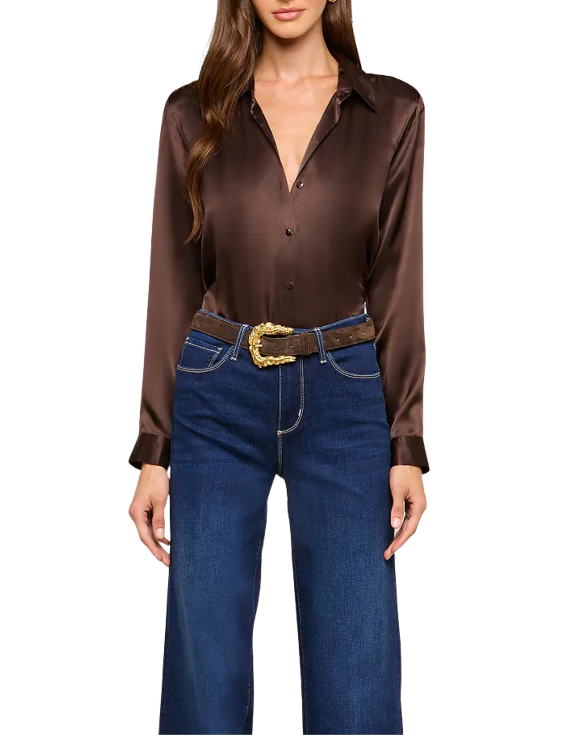 A woman wearing a long-sleeve brown satin button-up shirt tucked into dark blue jeans with a brown belt featuring a gold buckle, against a plain white background.