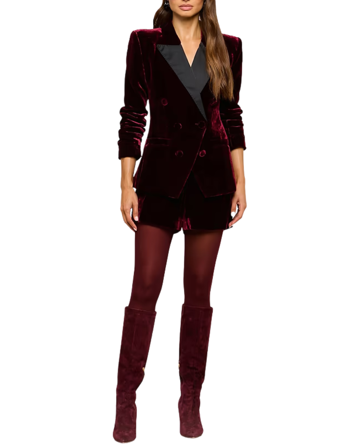 A woman modeling a dark burgundy velvet blazer with contrasting black lapels, matching velvet shorts, sheer burgundy tights, and matching velvet knee-high boots, set against a plain white background.