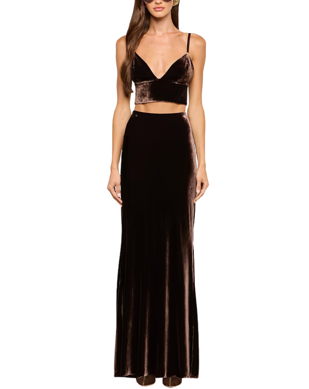 A woman modeling a dark brown velvet two-piece outfit consisting of a spaghetti-strap crop top and a matching high-waisted maxi skirt, set against a plain white background.