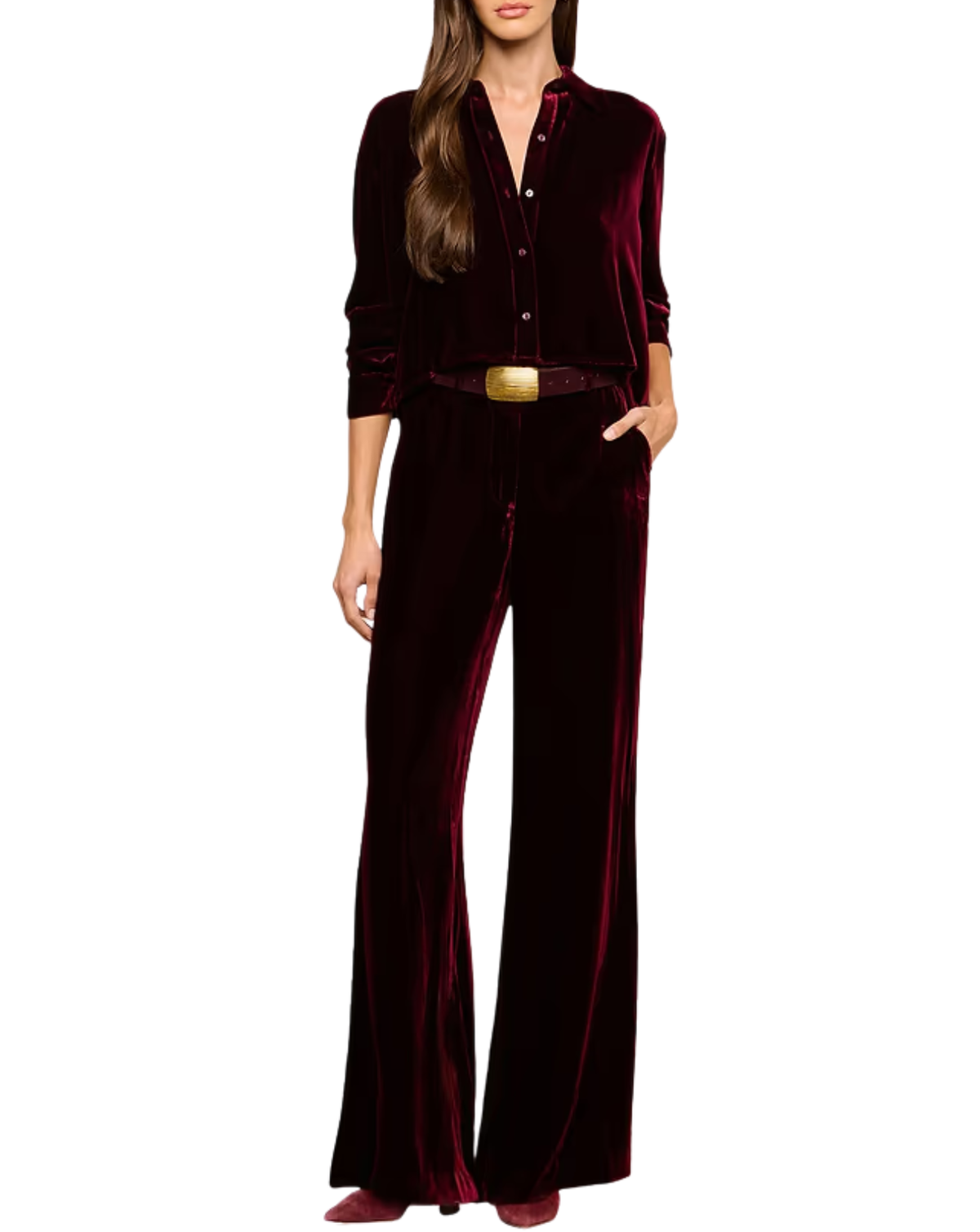 A woman modeling a deep burgundy velvet jumpsuit with a button-up front, long sleeves, and wide-leg pants, styled with a matching belt and gold buckle on a plain white background.