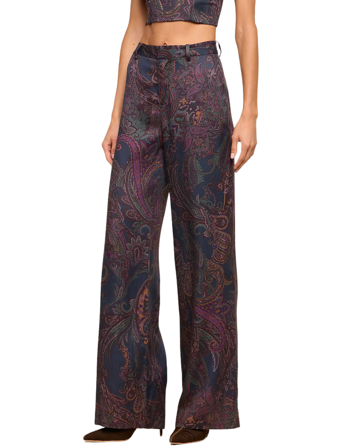 A model wearing high-waisted, wide-leg trousers with a dark blue and purple paisley pattern, paired with a matching crop top and brown heels, shown against a plain white background.