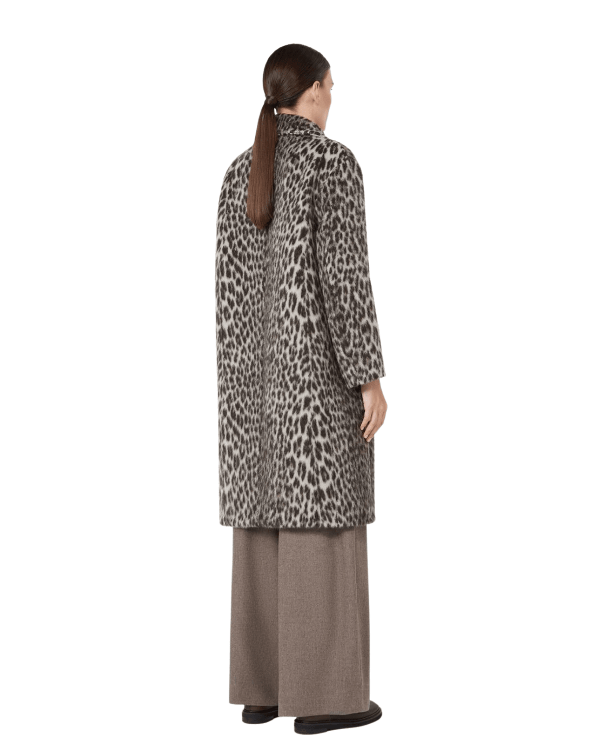 A woman shown from the back wearing a leopard-print coat over wide-leg taupe trousers, photographed against a plain white studio background.