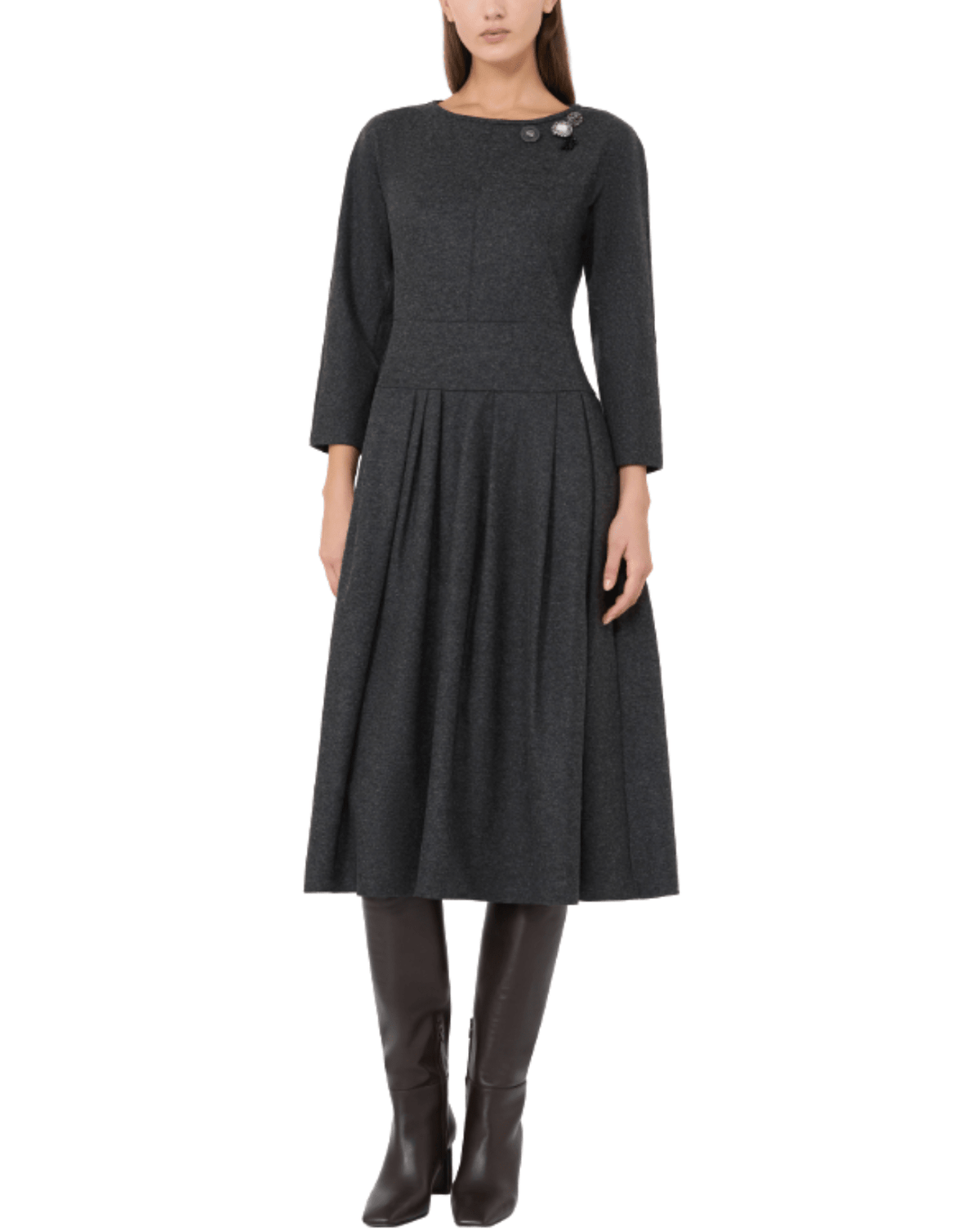 A woman modeling a dark charcoal gray wool-blend dress with three-quarter sleeves, a structured waist, and a pleated skirt, paired with dark brown knee-high boots against a plain white background.