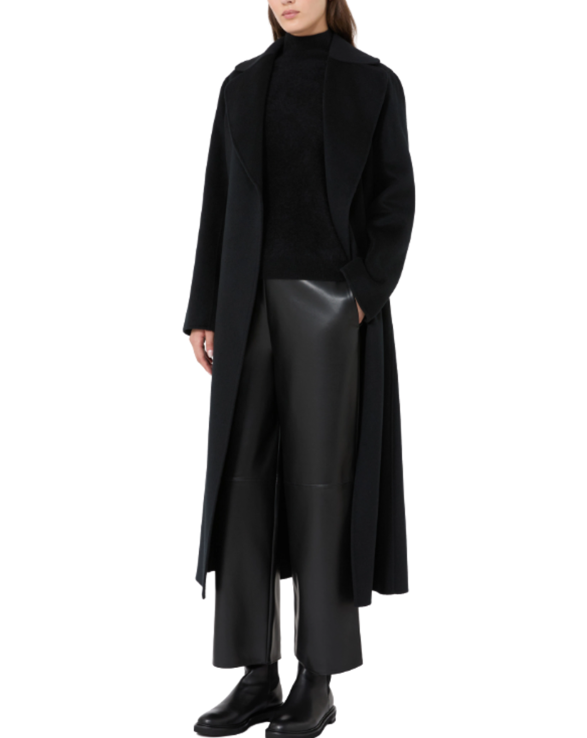 A model wearing a long black open-front coat over a black turtleneck sweater, black wide-leg leather pants, and black leather boots, shot against a solid white background.