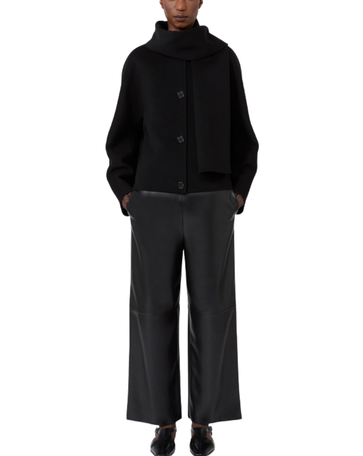 A model wearing a black cropped knit cardigan with a high folded collar and three front buttons, paired with wide-leg black trousers and black shoes, shown against a plain white background.