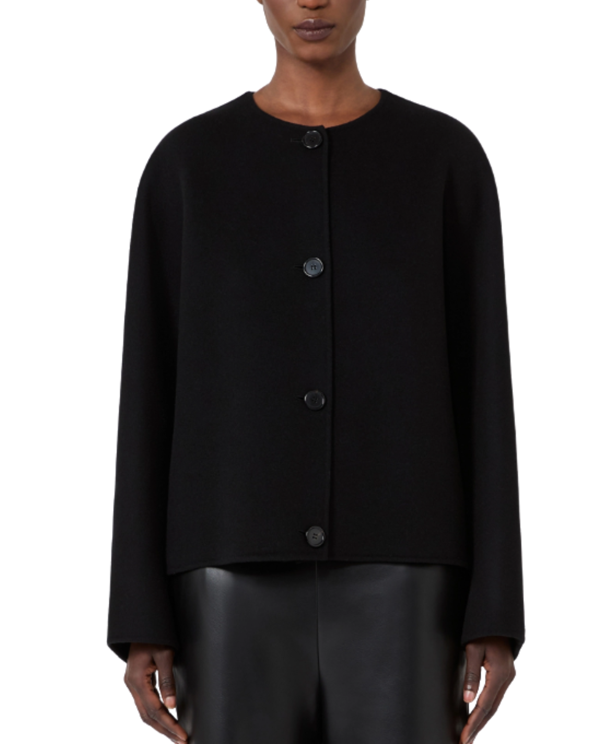 A model wearing a black cropped cardigan with a round neckline and three dark buttons, paired with black leather pants, against a plain white background.