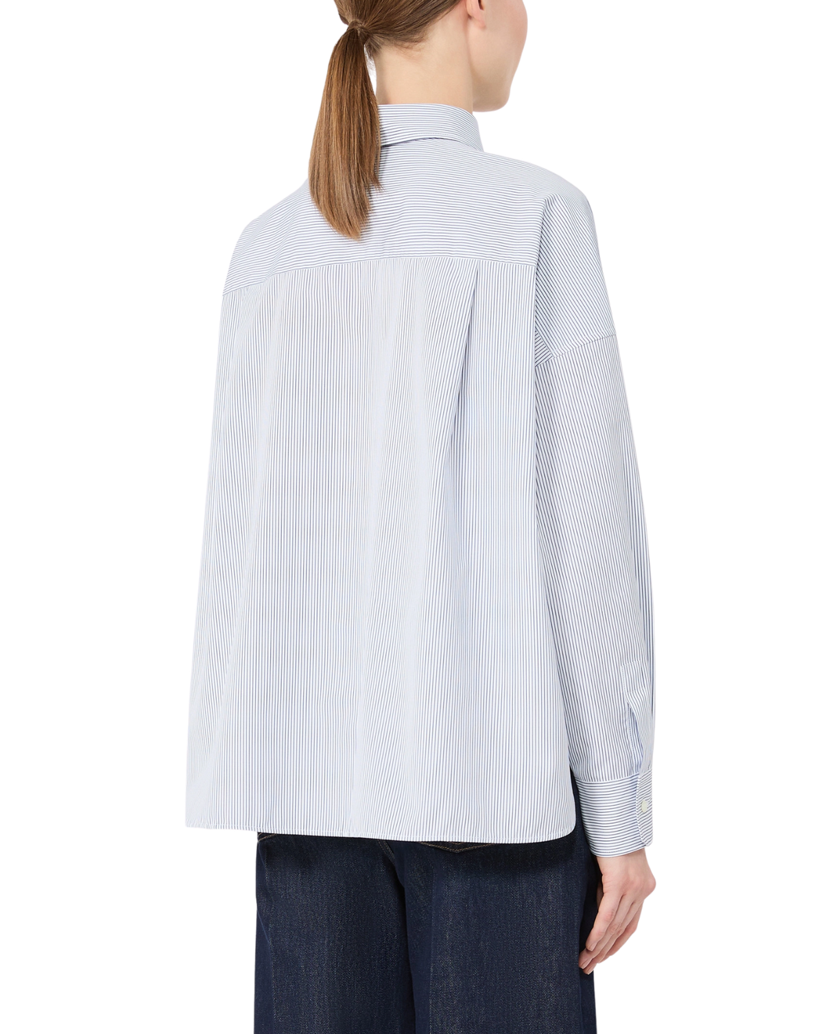 A woman shown from the back wearing a light blue and white vertically striped long-sleeve shirt and dark blue jeans against a plain white background.