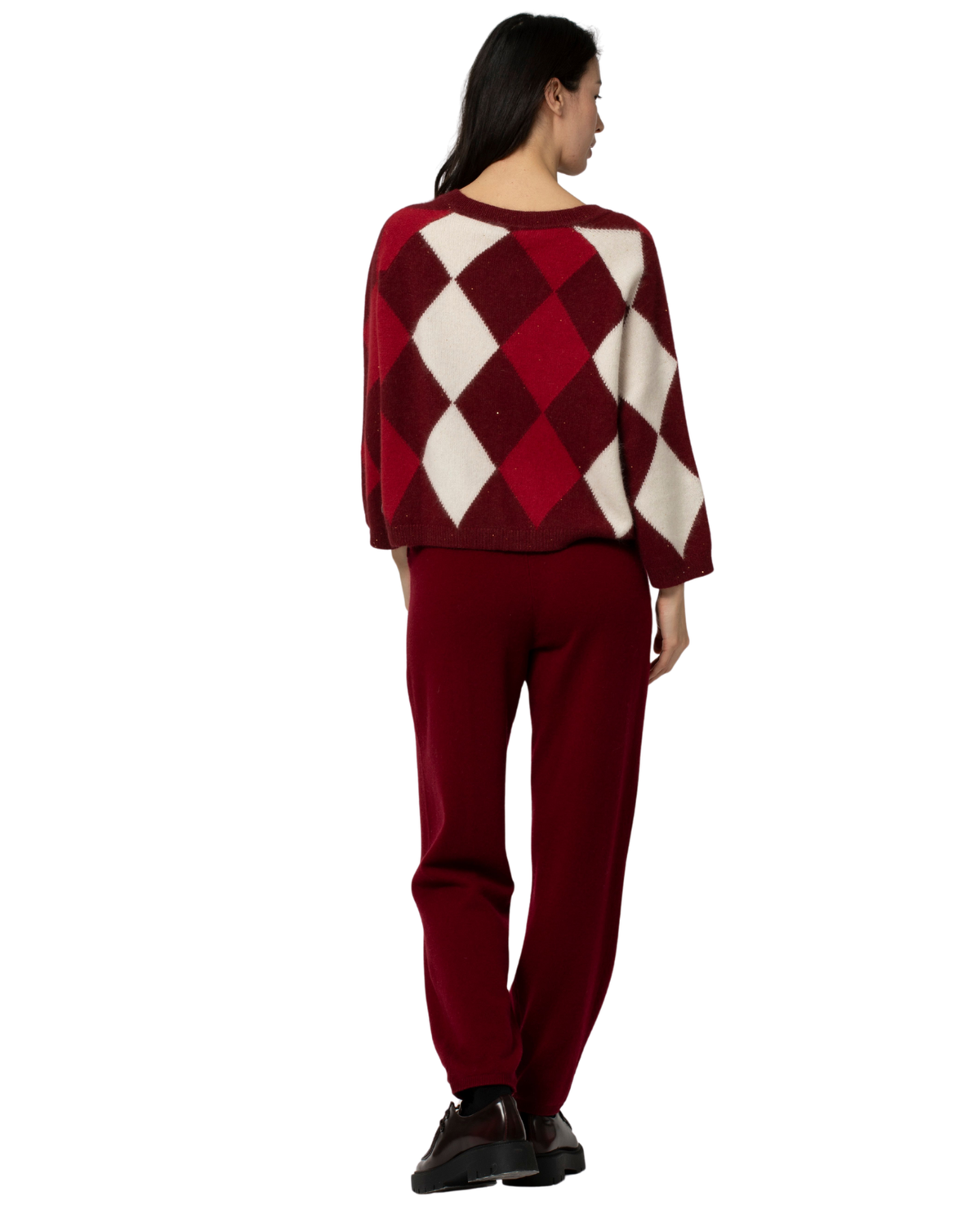 A woman shown from the back wearing a burgundy and cream argyle sweater and matching burgundy pants, paired with black shoes, against a plain white background.