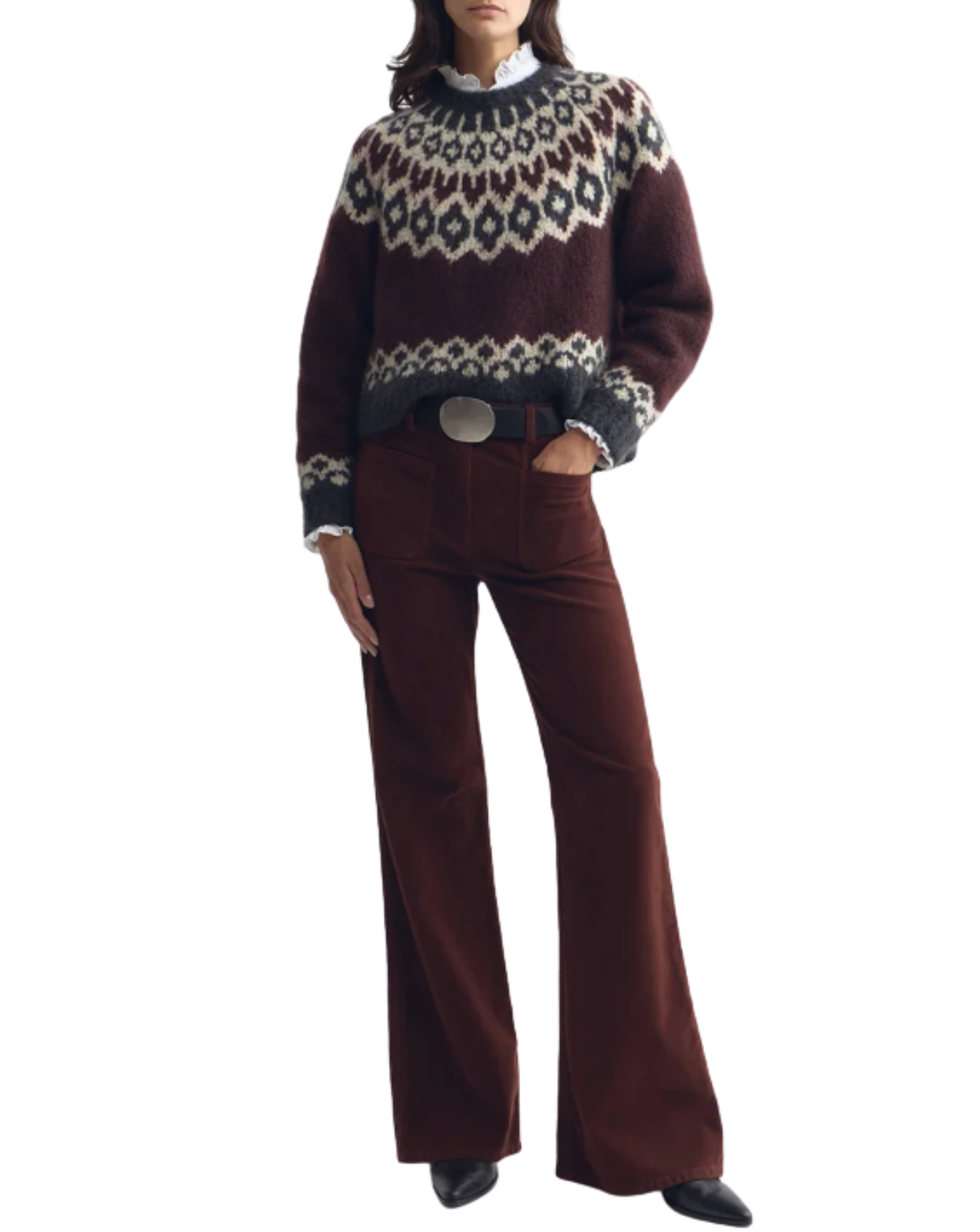 A model wearing a dark brown Fair Isle knit sweater with cream and navy patterns, paired with matching dark brown wide-leg trousers, a white collared shirt, and black shoes, shown against a plain white background.