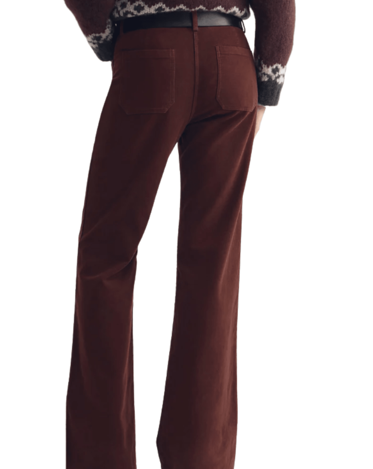 Rear view of a person wearing brown wide-leg corduroy trousers with a black belt and a patterned sweater, against a plain white background.