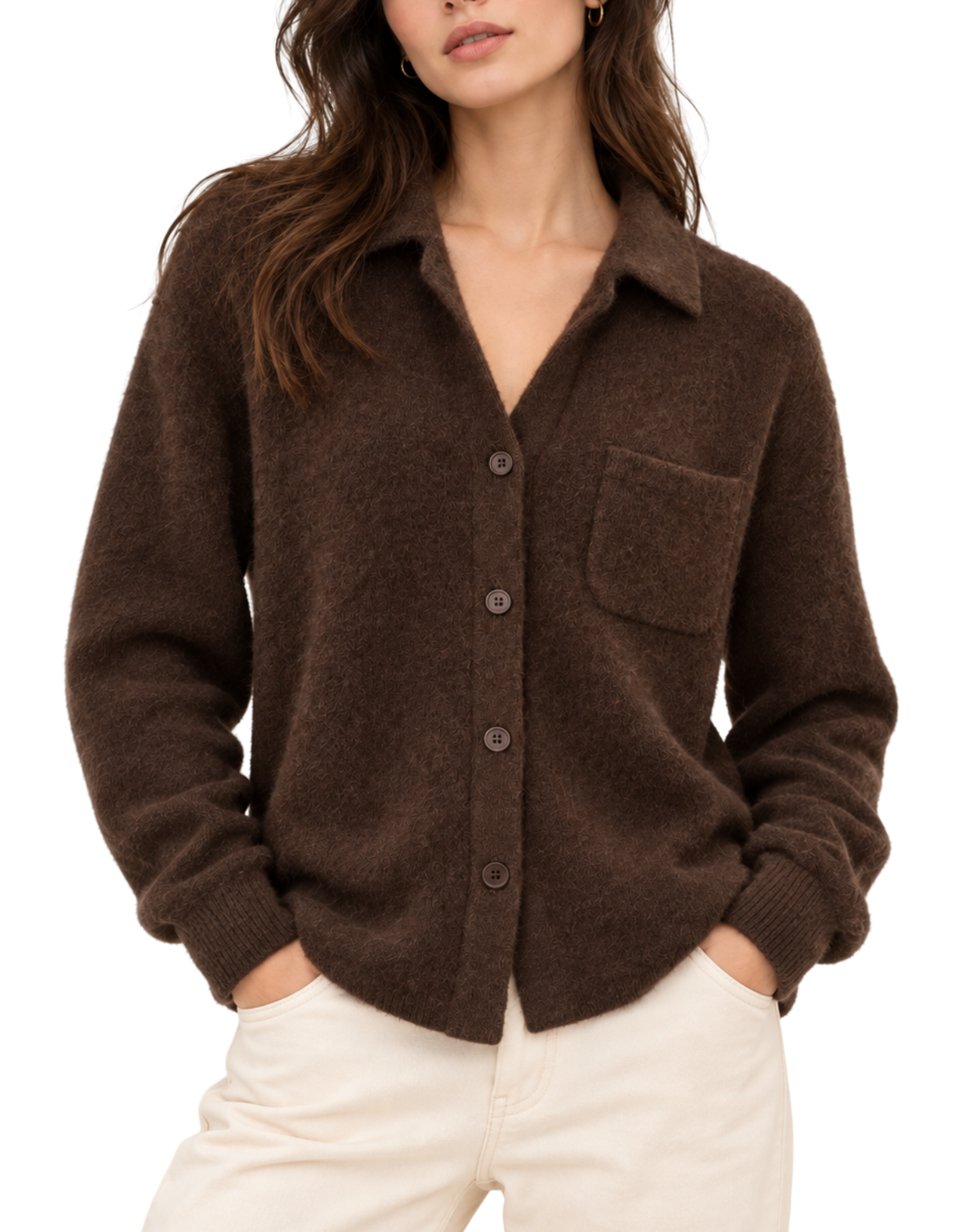 A woman wearing a dark brown fuzzy knit button-up cardigan with a chest pocket, paired with off-white pants, against a plain white background.