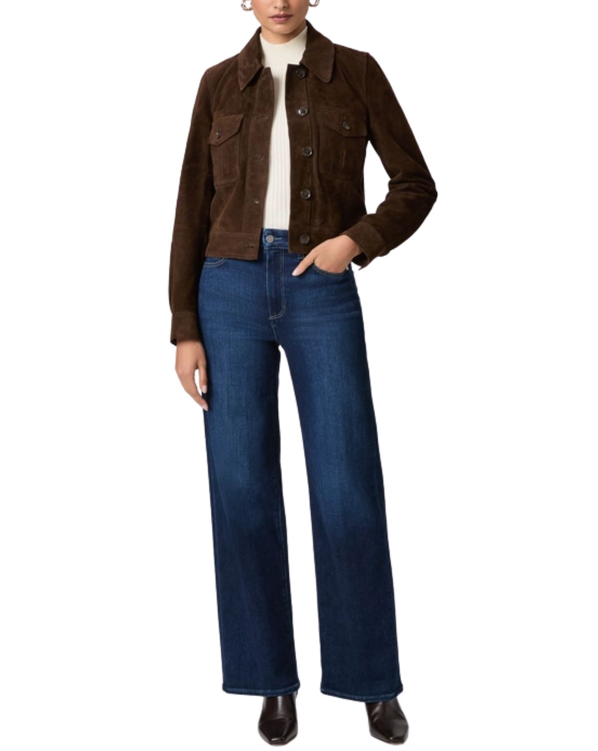 A model wearing a brown suede cropped jacket over a white turtleneck, paired with dark blue wide-leg jeans and black boots, shot against a solid white background.