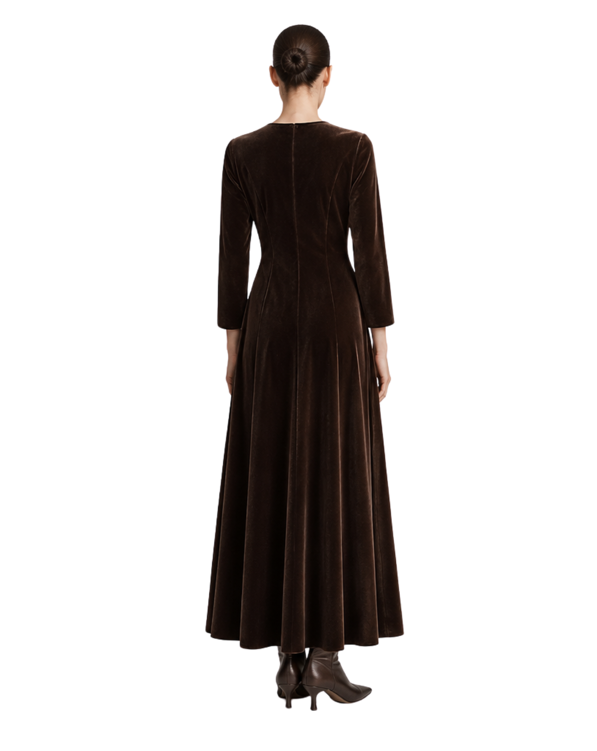 A woman viewed from the back wearing a long dark brown velvet dress with three-quarter sleeves and brown ankle boots, set against a plain white background.