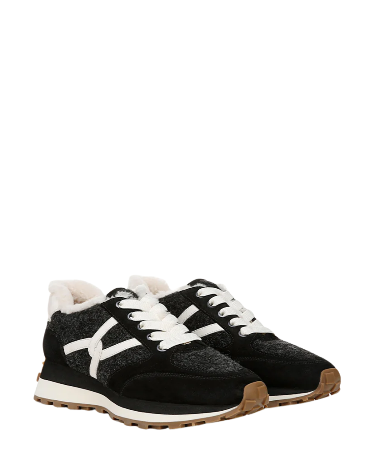 A pair of black low-top sneakers with white laces, a white X-shaped side logo, white faux-fur lining at the collar, and a brown gum outsole, shown against a plain white background.
