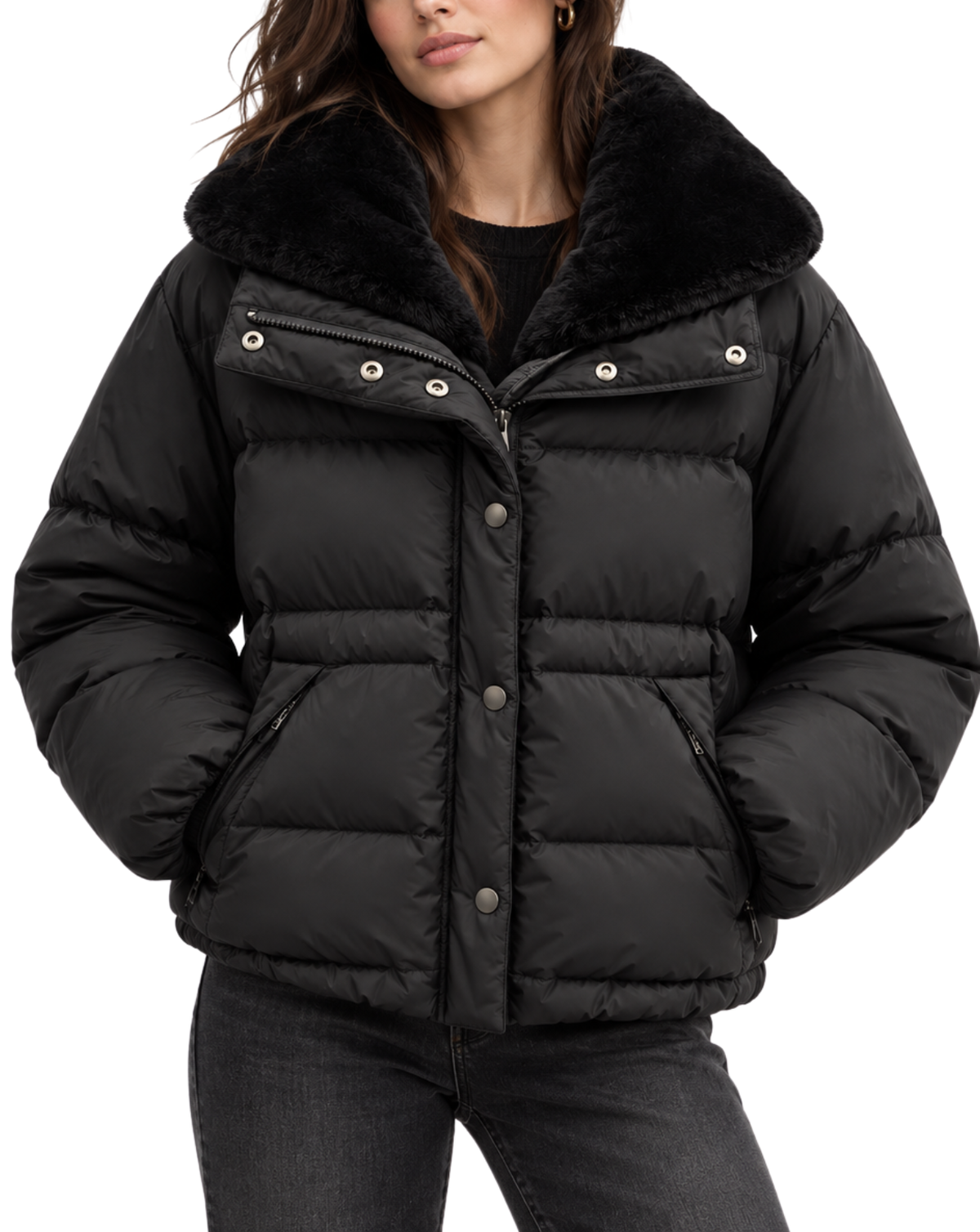 A woman wearing a black puffer jacket with a plush black faux-fur collar, shown from the chest down against a plain white background.