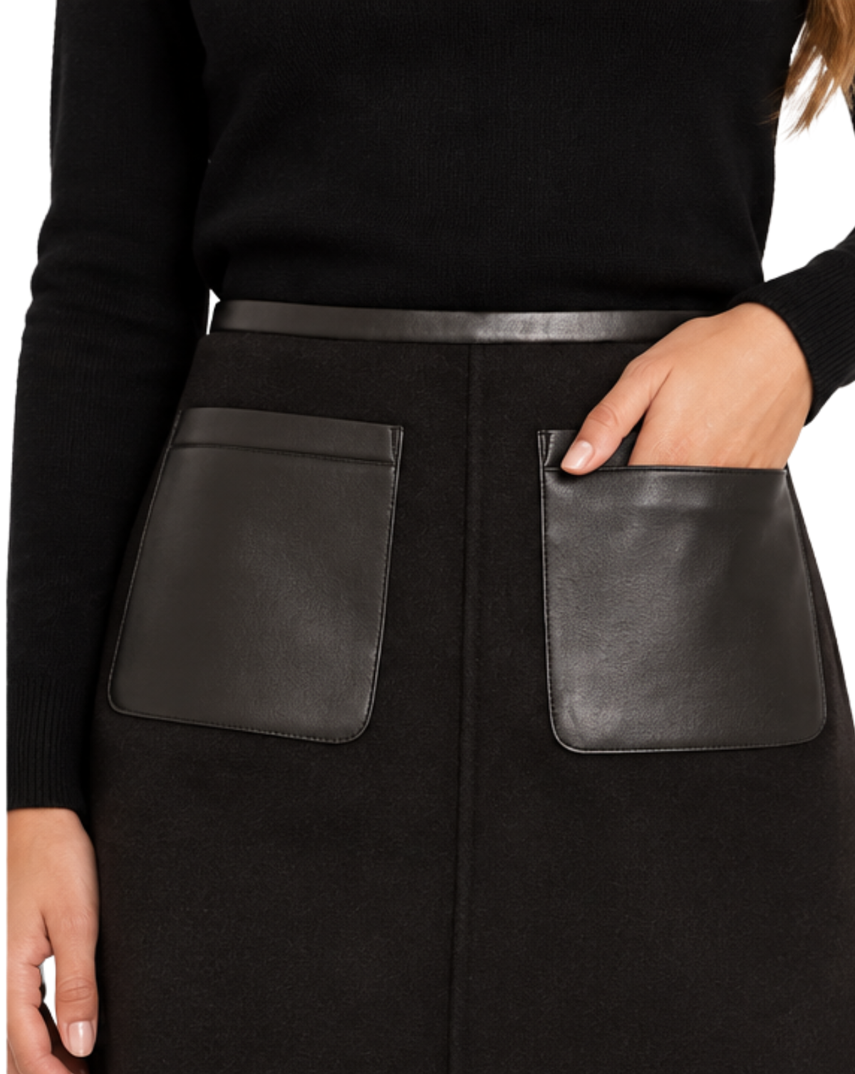 Close-up of a black skirt with two large black faux-leather patch pockets and a matching black belt, worn with a black ribbed top. A hand is shown in the right pocket.