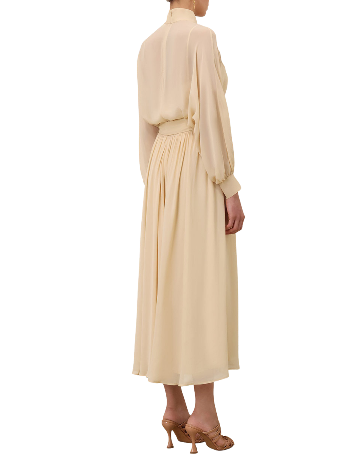 A model shown from the back wearing a long-sleeved, high-neck midi dress in a soft cream or pale beige color, paired with brown high-heeled sandals, against a plain white background.