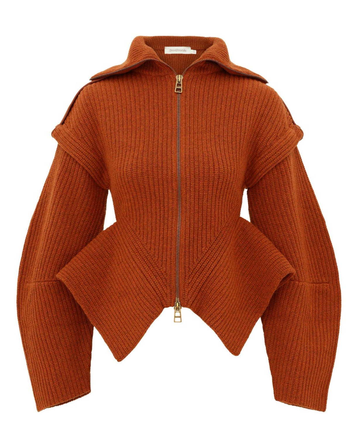 A rust-orange ribbed knit zip-up sweater with a high collar, shoulder cutouts, and an asymmetrical draped hem, shown on a plain white background.